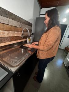 a woman standing in a kitchen holding a pizza at Village Conti Ideal para casal com Ar C01 in Campinas +82 photos