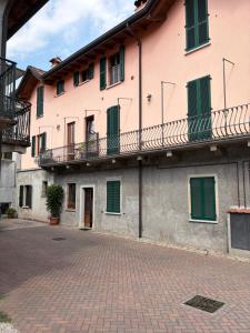 a building with green shutters and a balcony at Casa Chiara in Mandello del Lario