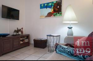 a living room with a couch and a flat screen tv at Kaz'Iguan in Saint-François