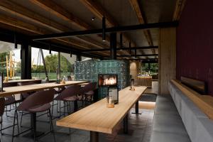 a restaurant with wooden tables and a fireplace at Resort Na Peci in Nová Pec
