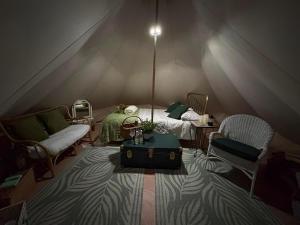 a room with a tent with a bed and chairs at Rogarnet caravan park in Three Legged Cross