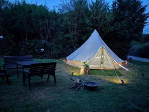 a tent in a field with a grill and a table at Rogarnet caravan park in Three Legged Cross