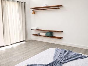 a living room with a bed and a white wall at Villa Isora in Talamanca +6 photos