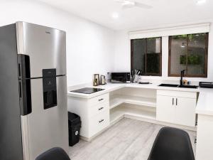 a kitchen with white cabinets and a refrigerator at Villa Isora in Talamanca