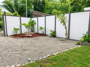 a backyard with a white fence and a garden at Villa Isora in Talamanca