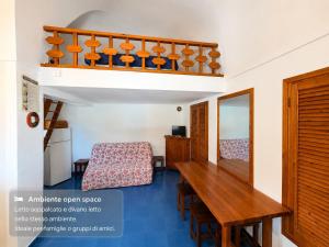 a room with a wooden table and a chair at Dammuso Ziloto - Cala Levante & Arco dell'Elefante in Pantelleria