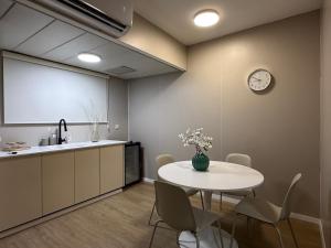 a kitchen with a table and a clock on the wall at קו המים - Waterline סוויטות עם גקוזי הכי קרוב לים in Netanya