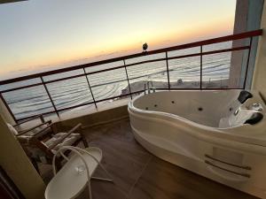 a bath tub in a bathroom with a view of the ocean at קו המים - Waterline סוויטות עם גקוזי הכי קרוב לים in Netanya +15 photos