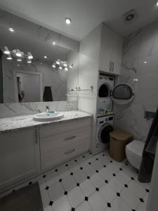 a bathroom with a sink and a washing machine at 56 Жемчужина in Odesa