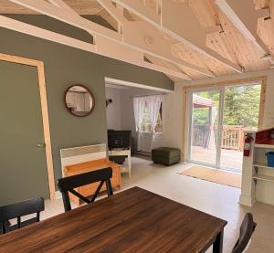 a living room with a wooden table and a dining room at L'Opie in Saint Adolphe D'Howard