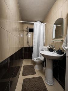 a bathroom with a toilet and a sink and a shower at Pure Sleep in Prizren