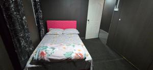 a small bedroom with a bed with a pink headboard at Haven Apartments- Nadi in Nadi