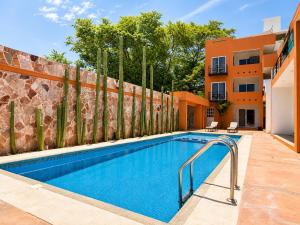 a swimming pool in front of a building at La Aurora Puerto Escondido in Puerto Escondido