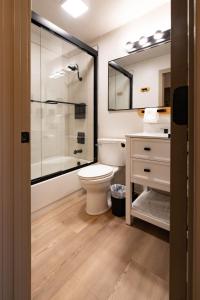 a bathroom with a toilet and a shower and a sink at Highliner Suites Hotel in Anchorage +25 photos