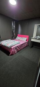 a bedroom with a pink bed and a table at Haven Apartments- Nadi in Nadi