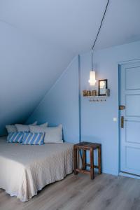 a bedroom with blue walls and a bed with a table at Hotel Villa Lejet in Tisvilde