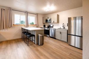 a kitchen with a refrigerator and a table and chairs at Highliner Suites Hotel in Anchorage