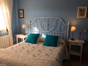 a bedroom with a bed with two green pillows at La Senda Del Duratón in Sebúlcor