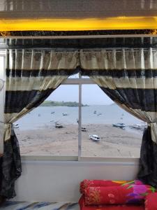 a bedroom window with a view of a beach at Homestay SeAngel in Labuan Bajo