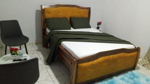 a bedroom with a wooden bed and a chair at Résidence IRIS Yamoussoukro in Yamoussoukro