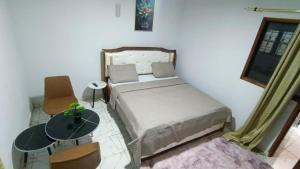 a small bedroom with a bed and a table at Résidence IRIS Yamoussoukro in Yamoussoukro