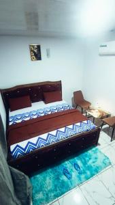 a bedroom with a bed with a blue and white comforter at Résidence IRIS Yamoussoukro in Yamoussoukro