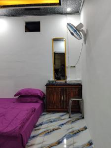 a bedroom with a bed and a dresser and a mirror at Homestay SeAngel in Labuan Bajo
