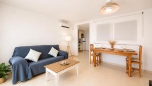 a living room with a blue couch and a table at Apartment with pool in Cala Millor in Cala Millor