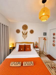 a bedroom with a bed with an orange blanket at MCRentals Siquijor in San Juan