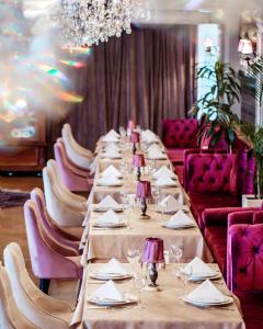 a long table in a room with purple chairs at Hotel Volga EGG Grand Inn Near Delhi Airport in New Delhi