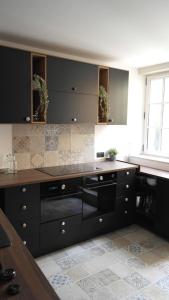 a kitchen with black cabinets and a counter top at La Curiosité, Et Pop Et Chic ! in Poitiers