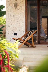 ein hölzerner Schaukelstuhl auf einer Veranda in der Unterkunft Salida Beach Zanzibar in Kizimkazi