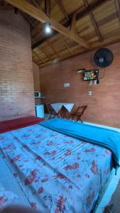 a large bed with a blue comforter in a room at Recanto Raios do Sol in Caldas +45 photos