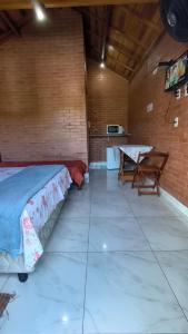 a room with a bed and a table in it at Recanto Raios do Sol in Caldas