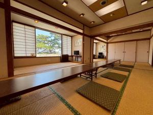 a large room with a row of tables and a window at パークホテル楽々園 in Maebashi