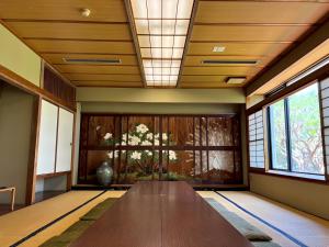 a large wooden table in a room with a window at パークホテル楽々園 in Maebashi