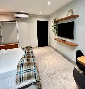 a bedroom with a bed and a flat screen tv at Seridó Acomodações in Caicó