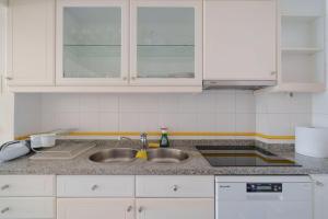 a kitchen counter with a sink and white cabinets at StaynFeel 03 in Fátima +42 photos