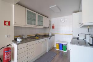 a kitchen with white cabinets and a sink at StaynFeel 03 in Fátima