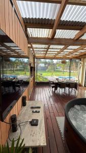 a large wooden deck with tables and a pool at Calma in Punta Colorada