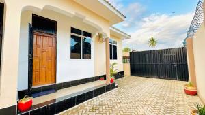 a house with a wooden door and a fence at Uluguru Breeze in Morogoro