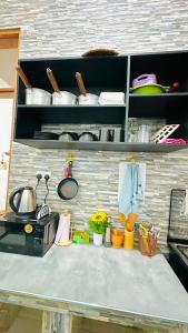 a kitchen counter with pots and pans on a shelf at Uluguru Breeze in Morogoro