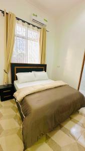 a large bed in a bedroom with a window at Uluguru Breeze in Morogoro