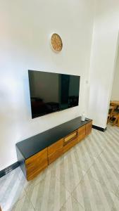 a living room with a large flat screen tv on a wall at Uluguru Breeze in Morogoro