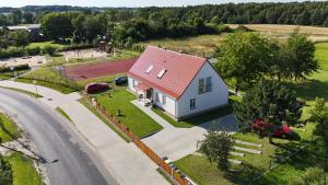 a white house with a red roof and a road at Apartamenty Kukinia33 in Kukinia