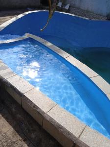 a large blue swimming pool with blue water at Casa grande in Serra
