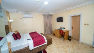 a hotel room with a bed and a desk at Charriot Hotels in Abuja