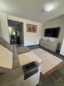 a living room with a couch and a flat screen tv at Rondon Sunset Belas Artes - 3Q - 3 salas - Sacada in Uberlândia