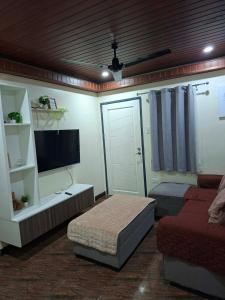 ein Wohnzimmer mit Bett und Fernseher in der Unterkunft Brians Palace in Tagum