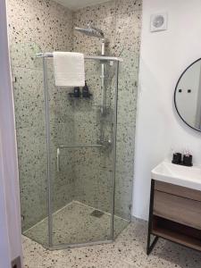 a bathroom with a glass shower and a sink at Container House Zakani in Zak'at'kari